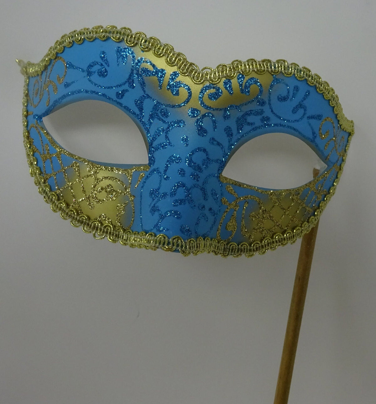 Turquoise Blue and Gold Masquerade Mask Hand Held on a Wooden Stick
