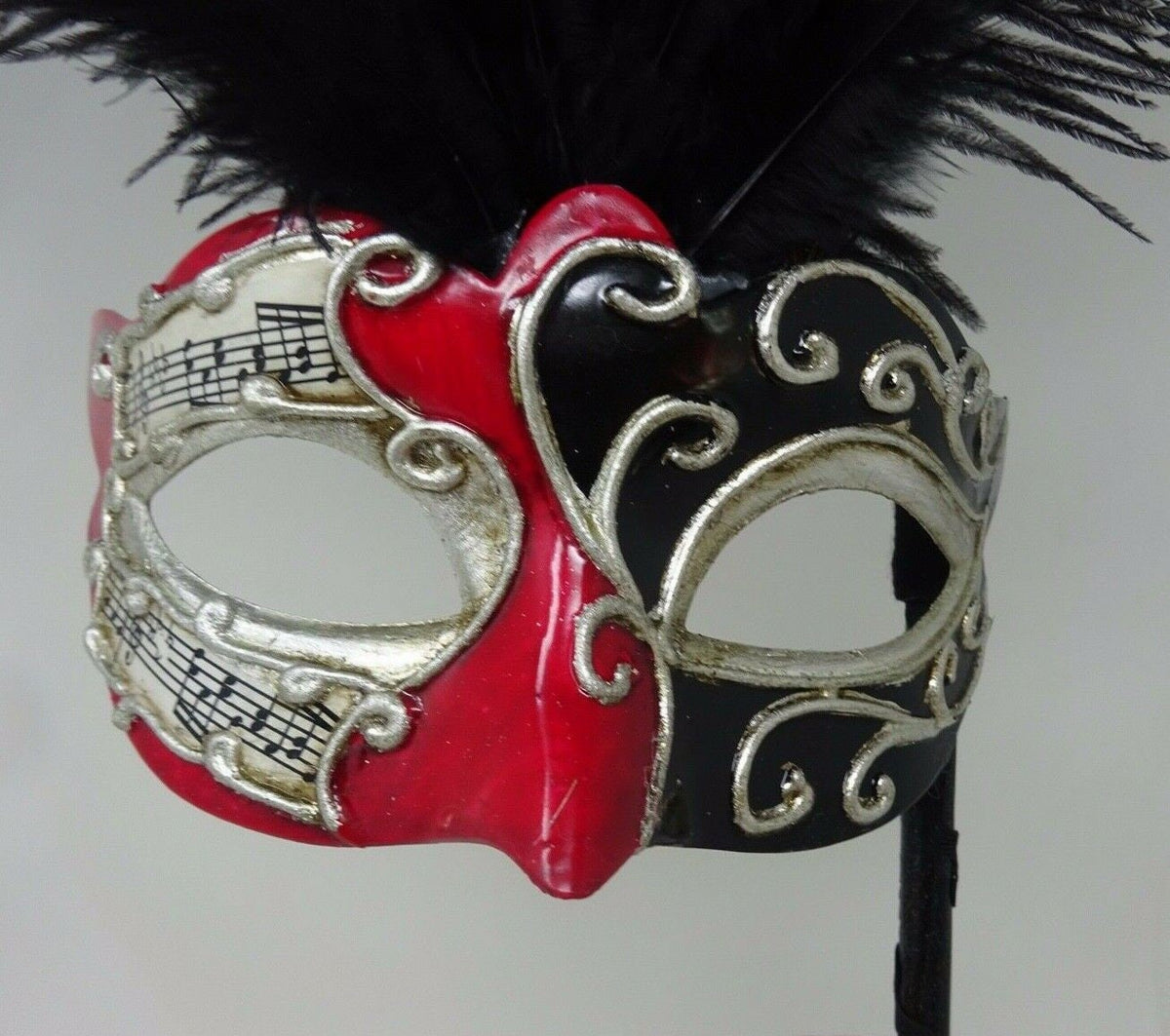 Ladies Red, Black and Silver Musical Masquerade Mask for Masked Ball with Layered Long Black Feathers Hand Held on a Wooden Stick