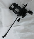 Stunning Black Masquerade Mask on a Black Stick with a flower made of black fabric petals, feathers and black and white organza