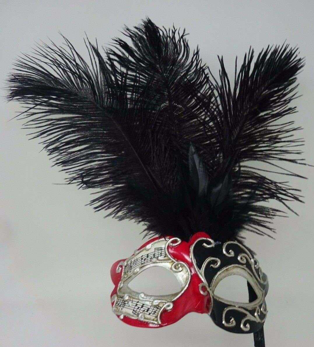 Ladies Red, Black and Silver Musical Masquerade Mask for Masked Ball with Layered Long Black Feathers Hand Held on a Wooden Stick